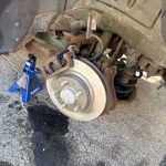Mobile mechanic performing rear brake repair on a 2008 Ford Fusion in Sheboygan County, Wisconsin.